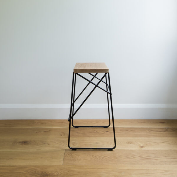 Sideview of black wire kitchen stool with criss cross legs & solid oak seat