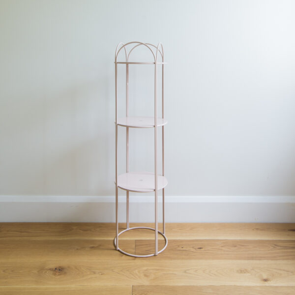 Blush coloured round metal wire stand for plants and homewares.